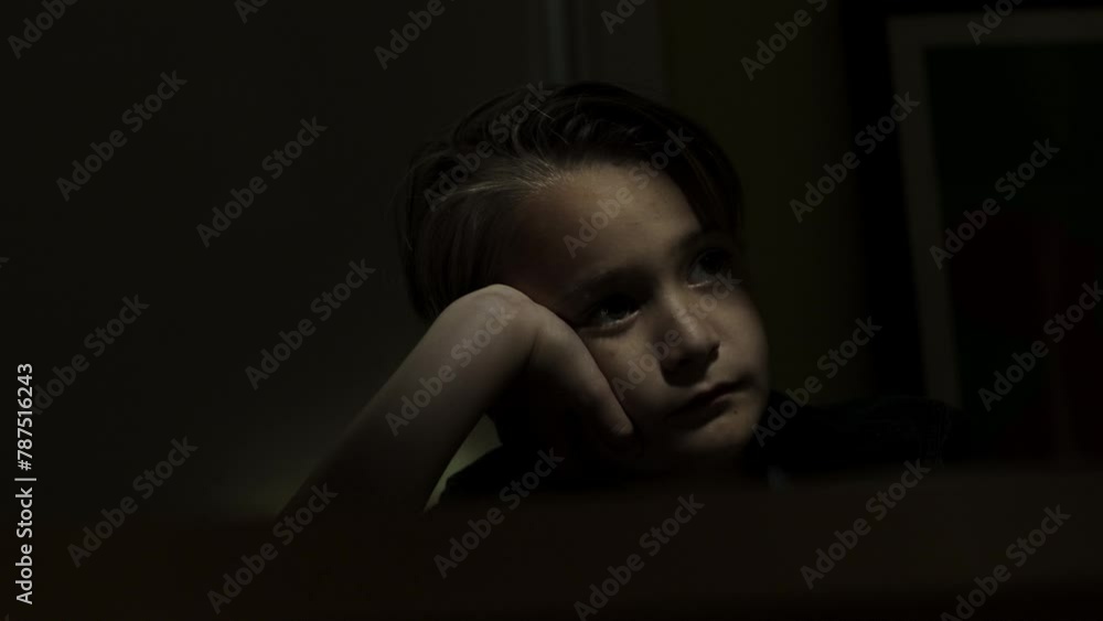 Young worried boy sits in a dark room alone Young worried boy sits in a dark room alone