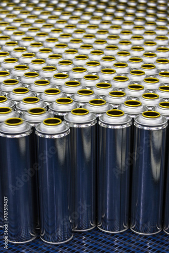 Cans, group of many empty valveless aerosol cans in manufacturing process, aerosol manufacturing photo