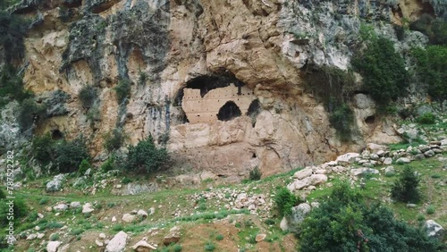 Drone footage showcases historical ruins of ancient Christian three story rock church dating back to 7th century Eastern Roman Empire. The view highlights architectural remnants and cultural heritage photo