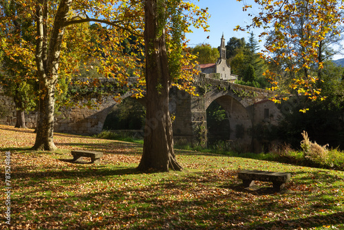 Romanesque stone bridge and Santa María de Vilanova church in the beautiful village of Allariz in autumn, Orense, Galicia, Spain. photo