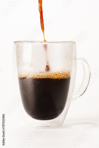 Cup of coffee, glass cup being placed coffee, white background, selective focus.