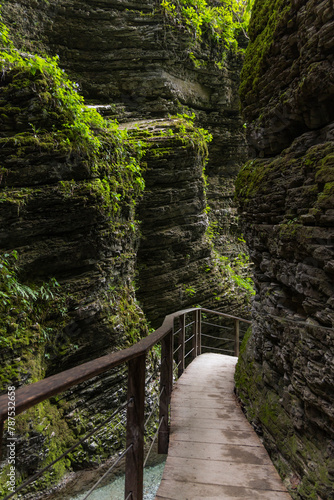 Caporetto, Slovenia. Kozjak waterfalls. Nature trail along the river with crystal clear, turquoise water, Tibetan bridges and a waterfall inside the cave with a nature pool. easy trekking, wood path.