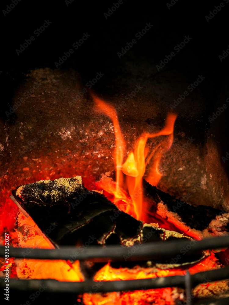 Naklejka premium Logs burning in fire place. Selective focus. Warm color.