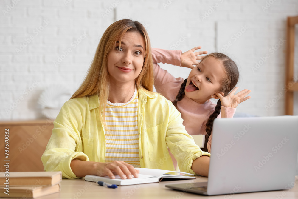 Working young woman stressed of her naughty little daughter at home Working young woman stressed of her naughty little daughter at home