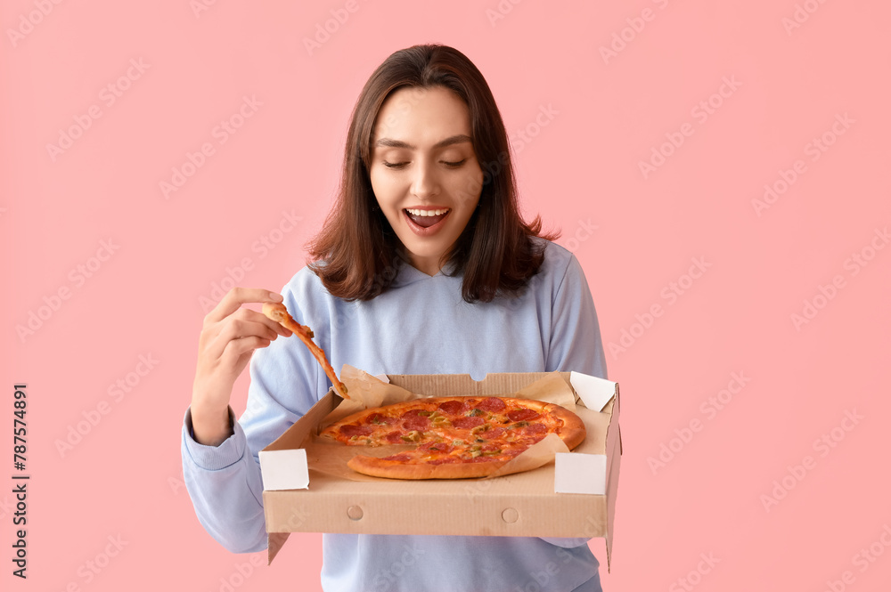 Young woman holding cardboard box with tasty pizza on pink background Young woman holding cardboard box with tasty pizza on pink background