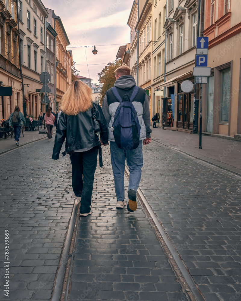An urban adventure for Gen Z couples in the evening in a historic European city, showcasing travel, togetherness and the charm of cobbled streets and tram tracks