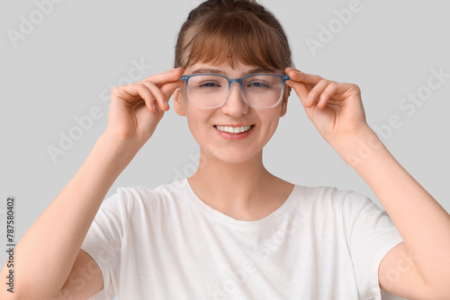 Young woman in eyeglasses on light background  closeup. Glaucoma awareness month