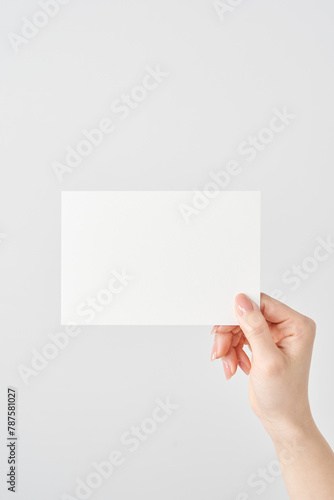 白い紙を持つ女性の手元