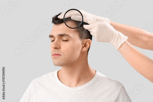 Doctor with magnifier exami...