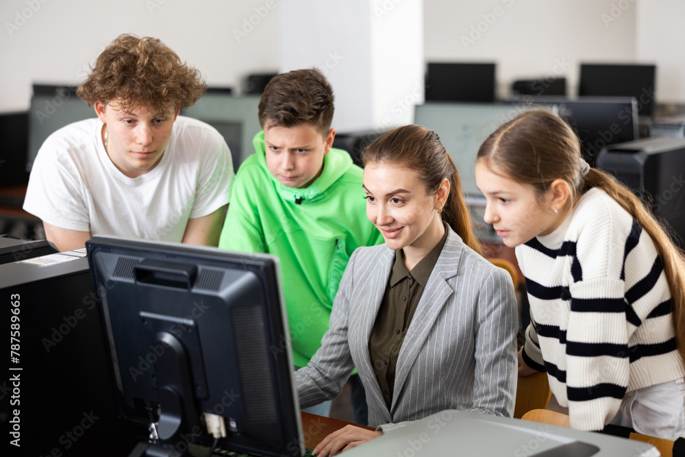 Fototapeta premium Teacher helping young student in computer class in university