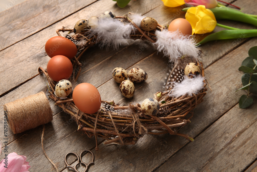 Tulips, supplies for creating Easter wreath with eggs and feathers on brown wooden background