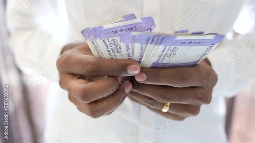 Indian men counting hundred rupees bank note photo