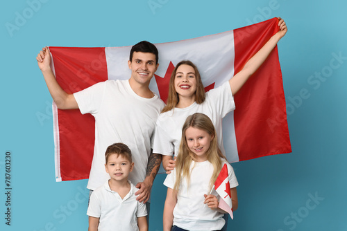 Beautiful family with flags of Canada on blue background