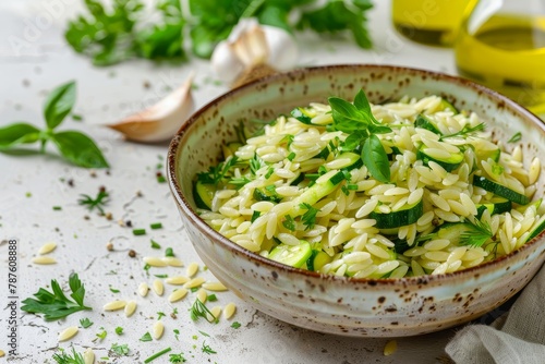Orzo salad with fried zucchini garlic and olive oil dressing in a bowl on concrete background Orzo and zucchini dishes