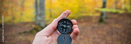Compass in man's hand, in the autumn forest