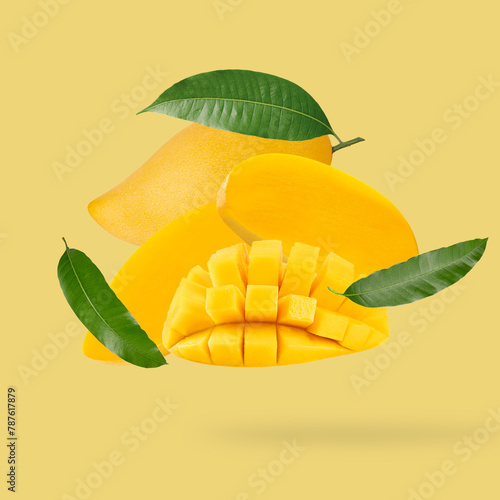 Falling Fresh mango fruit with leaves on yellow background.