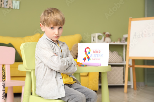 Upset little boy sitting at...