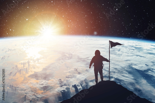 Silhouette of an astronaut with a flag against the backdrop of a planet and a shining star. Elements of this image furnished by NASA