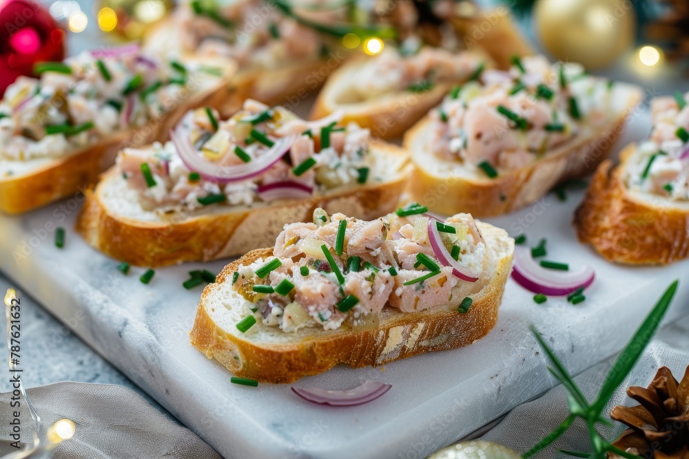 Baguette slices with tuna cream cheese onions and chives on a marble board Festive dinner table
