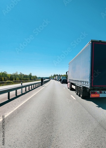Semi Truck On The Road In A Traffic Jam On A Sunny Day In Spring With A Clear Blue Sky In The Background, Leading To Delayed Deliveries And Increased Travel Time For Vehicles