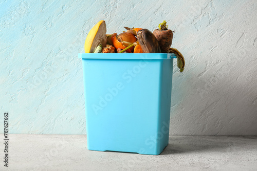 Fotografie Bucket with organic waste on white grunge table