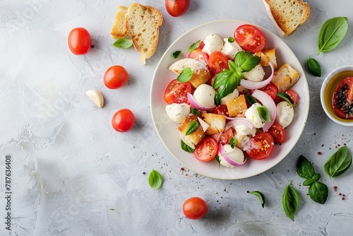 Italian Panzanella salad with tomatoes mozzarella basil onion and bread on grey background Traditional cuisine Top view with space for text