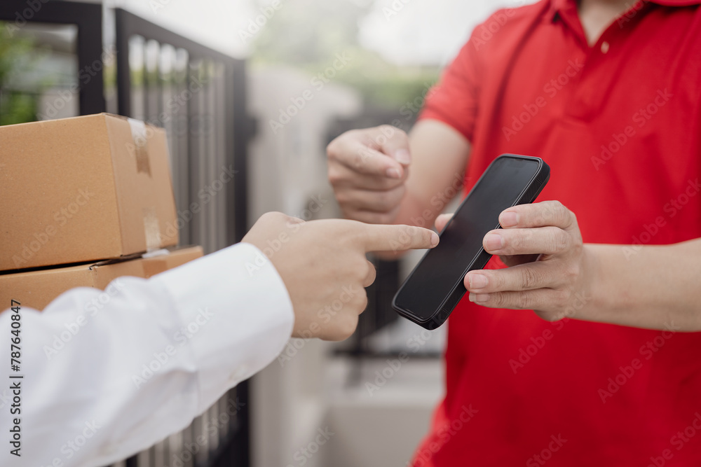 Logistics concept A parcel or delivery service stands at the door of a service provider or product for online shopping, shipping or e-commerce. .Close-up image of paying via mobile phone