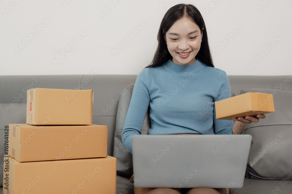 SME female entrepreneur works on receipt boxes and checks online orders to prepare boxes to sell to customers. SME business concept, order online, sell products, work with boxes, freelance work. SME female entrepreneur works on receipt boxes and checks online orders to prepare boxes to sell to customers. SME business concept, order online, sell products, work with boxes, freelance work.