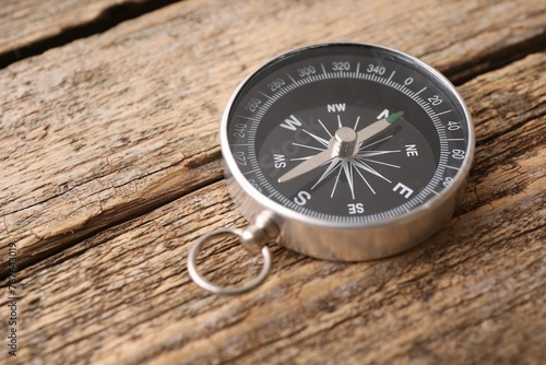 One compass on wooden table, space for text. Tourist equipment