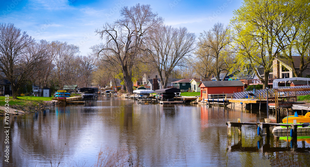 Obraz premium Tranquil fishing village springtime landscape at Wiicawak Bay in Lake Monona, Madison, Wisconsin, USA, moored boats and kayaks getting ready for the season