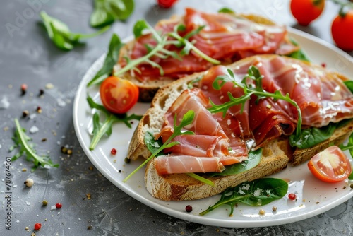 Fresh bread with ham arugula spinach and cherry tomatoes on a plate