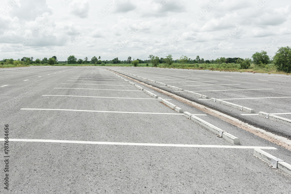 Obraz premium Empty parking lot against mountains and beautiful blue sky.