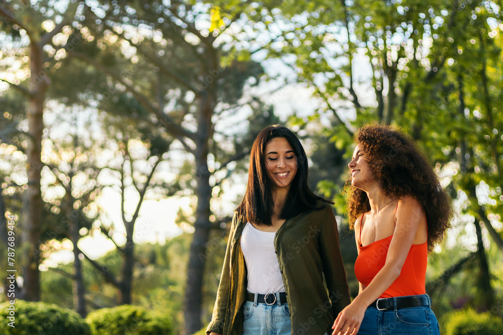 two young women couple walking in a park
