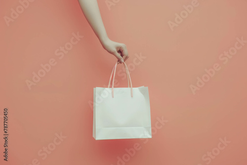 Capture the elegance of minimalism with a close-up shot of a woman's hand holding a white shopping bag against a peach fuzz wall mockup, AI generative. photo