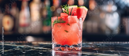 Fruitful watermelon mocktail adorned with fresh watermelon cubes and rosemary. photo