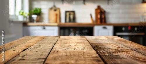 A wooden table is empty with a blurry kitchen background.
