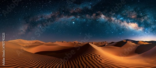A breathtaking view of the expansive desert landscape with numerous sand dunes stretching under the beautiful Milky Way night sky