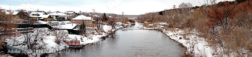 panoramic view of the coastal village on the banks of the Miass River in winter photo