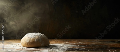 Dough on a wooden surface, set against a dark backdrop, leaving room for an item in a bakery. photo