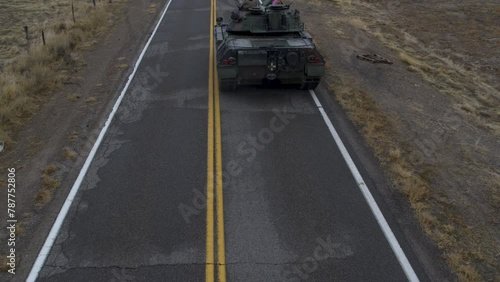 Large, old tank traveling down desert highway - drone shot