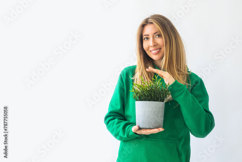 Beautiful blonde woman with long hair and wearing a stylish green sweatshirt looking at the camera