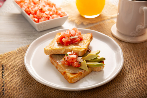 Breakfast toast with refried beans, avocado, melted cheese and mexican pico de gallo sauce. Easy and healthy homemade recipe that can be made in the oven, frying pan or air fryer.