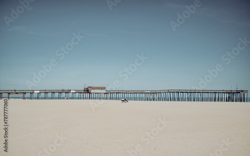 Sandy beach and calm sea with clear blue sky near Ocean City Maryland © @foxfotoco