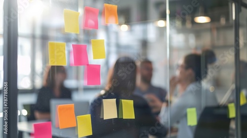 Business team brainstorming with sticky notes on a glass board while discussing ideas at a meeting table