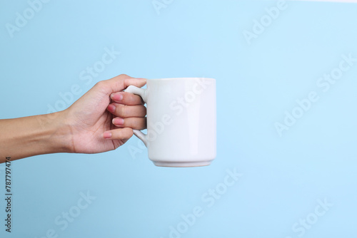 Hands Holding White Ceramic Mug for Mockup Isolated on Blue Background