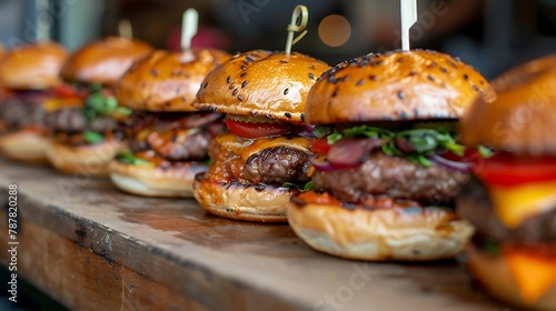 Close up image of a selection of freshly flame grilled burgers in a row on a wooden counter at borough market photo