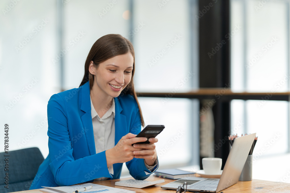 Young businesswoman manager, holding accounting bookkeeping documents checking financial data or marketing report working in office with laptop. Paperwork management Young businesswoman manager, holding accounting bookkeeping documents checking financial data or marketing report working in office with laptop. Paperwork management