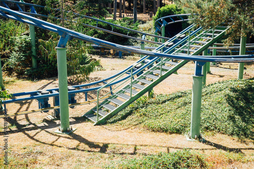 Manège à sensation. Petit train dans un parc d'attraction. Manège à vitesse. Rails élevées pour un train. Rails en hauteur. Rampe et ascension d'un manège. Fête foraine dans un milieu naturel. Manège à sensation. Petit train dans un parc d'attraction. Manège à vitesse. Rails élevées pour un train. Rails en hauteur. Rampe et ascension d'un manège. Fête foraine dans un milieu naturel.