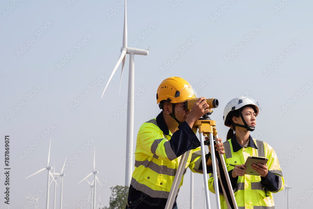 Male engineer and female engineer Survey the area to install wind turbines for electrical energy production..Renewable energy, clean energy or environmental conservation concepts.