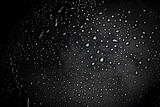 Closeup - rain water drops behind glass look like bubbles in black liquid. Abstract wet background.